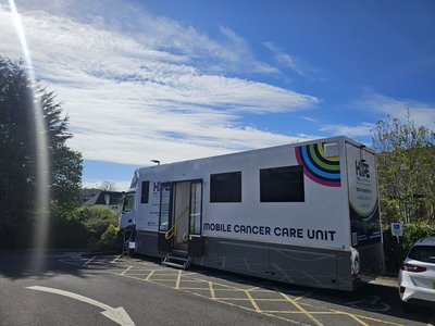 Exterior photograph with blue sky showing Gloucestershire Mobile Cancer Care Unit (MCCU)