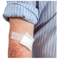 Close-up of an arm with a bandage and a rolled-up shirt sleeve.