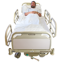 Man lying in a hospital bed with white sheets.