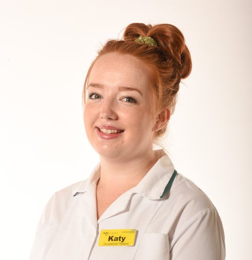 Photograph of Katy Williams in white occupational therapist&#x27;s uniform of white tunic with green edging