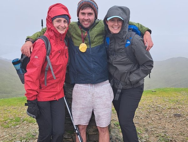 Sam celebrates reaching the summit of Helvellyn with physiotherapists Jenni and Kate who have supported his rehabilitation through the Gloucestershire Brain Injury Team.