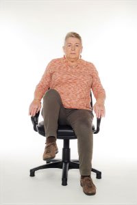 A woman doing chair marching exercises