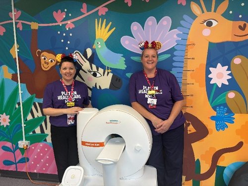 The play team with a model MRI machine to help children familiarise the process.